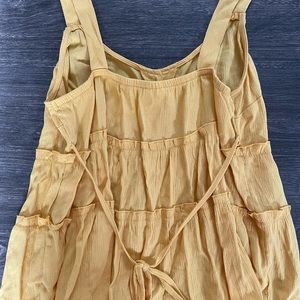 Cute yellow tank top with buttons and a tie in the back